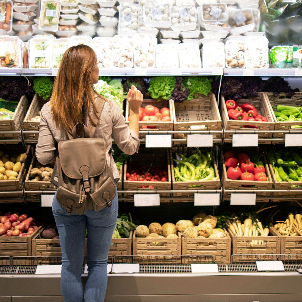 Frau an einem Obstregal im Supermarkt