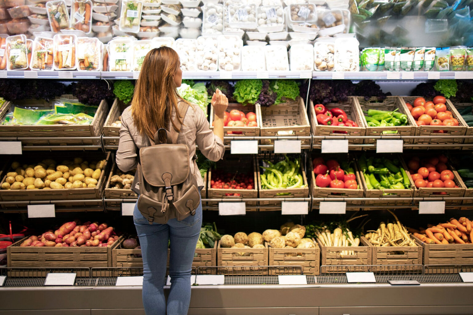 Frau an einem Obstregal im Supermarkt